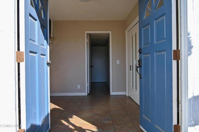 entryway featuring a textured ceiling and dark tile patterned floors