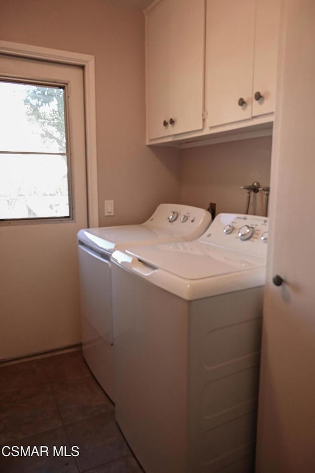 laundry room with cabinets, separate washer and dryer, and dark tile patterned floors