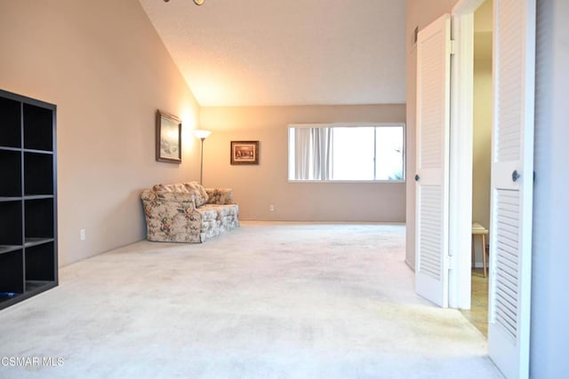 unfurnished room featuring vaulted ceiling and light carpet