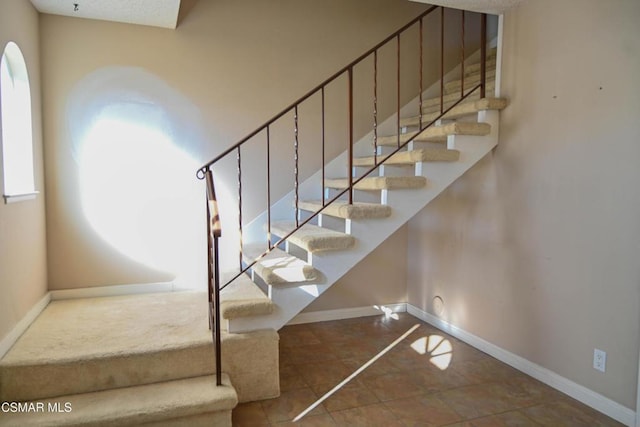 stairway with tile patterned floors