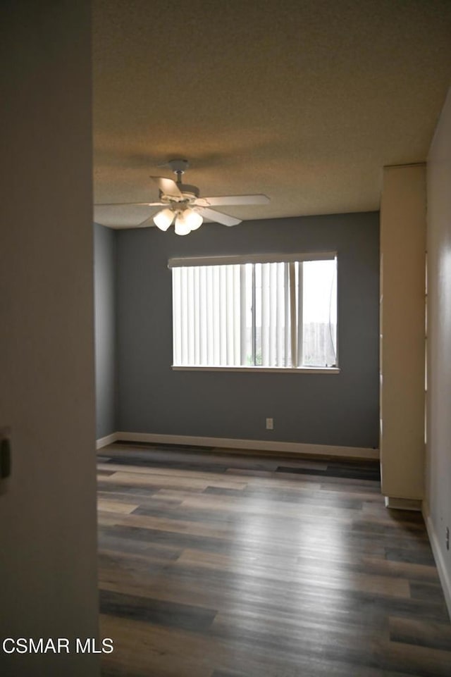 unfurnished room with dark hardwood / wood-style floors and ceiling fan