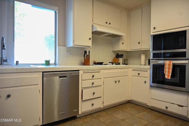 kitchen with light tile patterned floors, stainless steel appliances, sink, and white cabinets