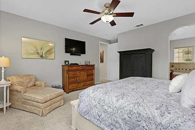 bedroom with ensuite bath, ceiling fan, and carpet flooring