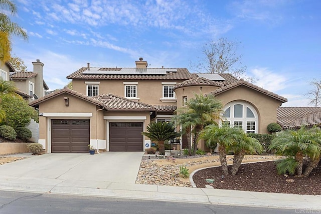 mediterranean / spanish-style home featuring a garage and solar panels