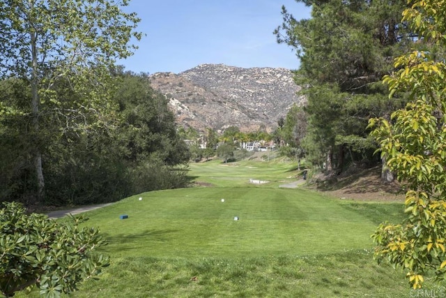 view of home's community with a mountain view and a lawn