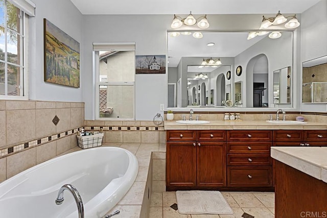 bathroom featuring tile patterned flooring, plus walk in shower, and vanity