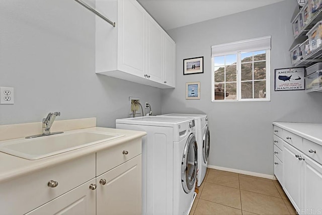 laundry area with cabinets, light tile patterned flooring, sink, and washing machine and clothes dryer