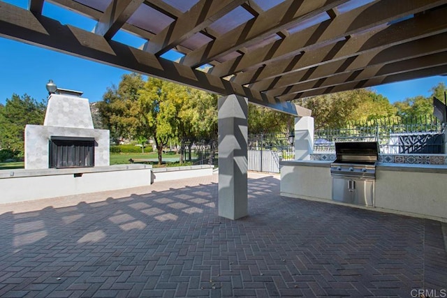 view of patio with a grill, a pergola, and an outdoor kitchen