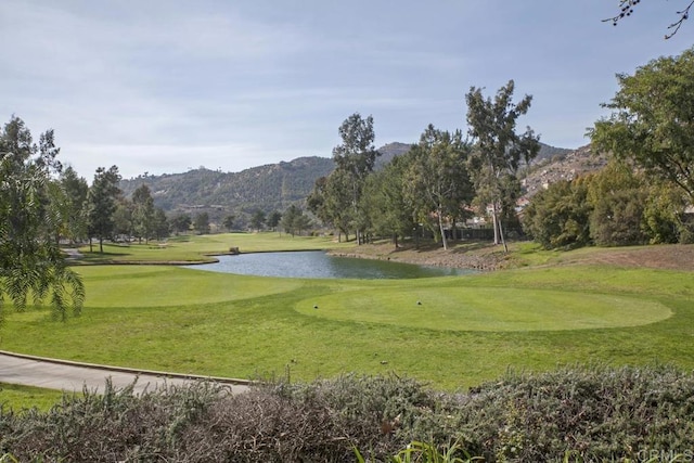 surrounding community with a water and mountain view and a lawn