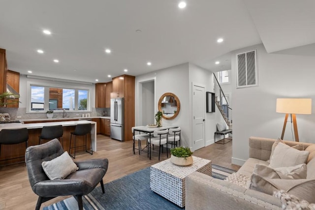 living room featuring sink and light hardwood / wood-style flooring