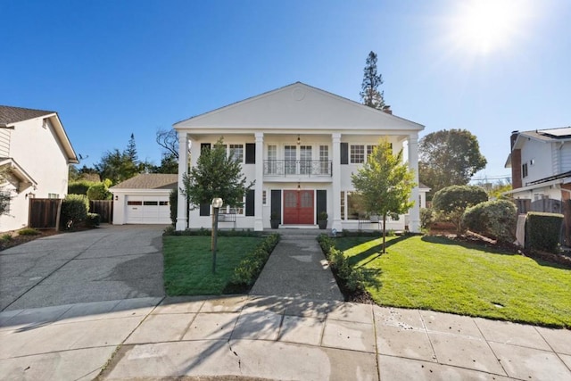 neoclassical / greek revival house with a balcony, a garage, and a front yard