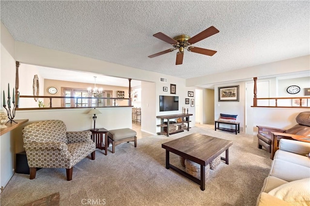 living room featuring ceiling fan with notable chandelier, a textured ceiling, and light carpet