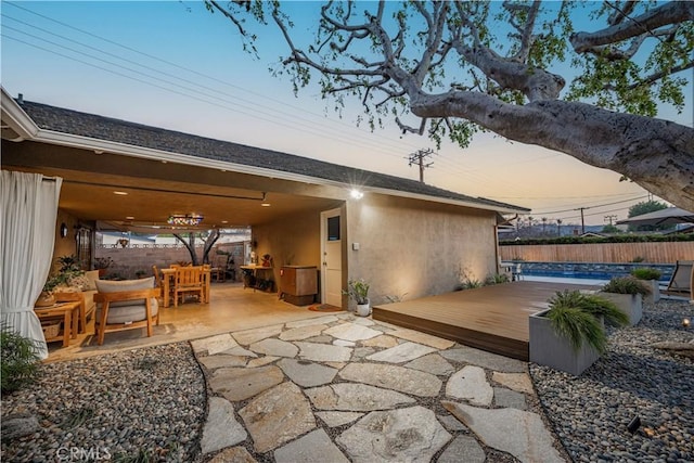 patio terrace at dusk featuring a deck