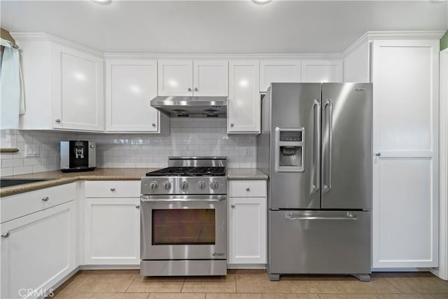 kitchen featuring white cabinetry, stainless steel appliances, dark stone counters, and tasteful backsplash