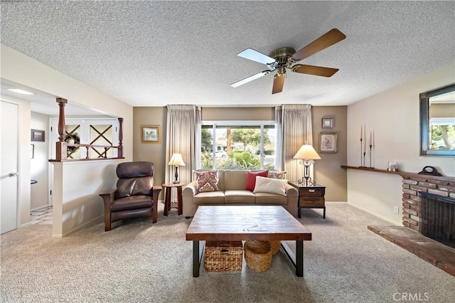 carpeted living room featuring a brick fireplace, a textured ceiling, and ceiling fan