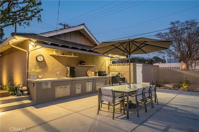 view of patio featuring sink, an outdoor kitchen, and a grill