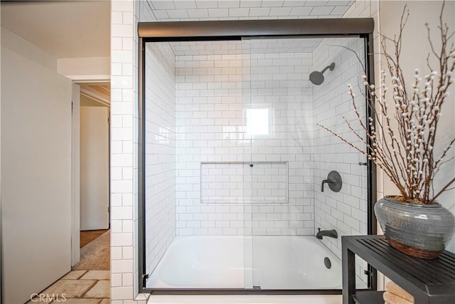 bathroom featuring combined bath / shower with glass door