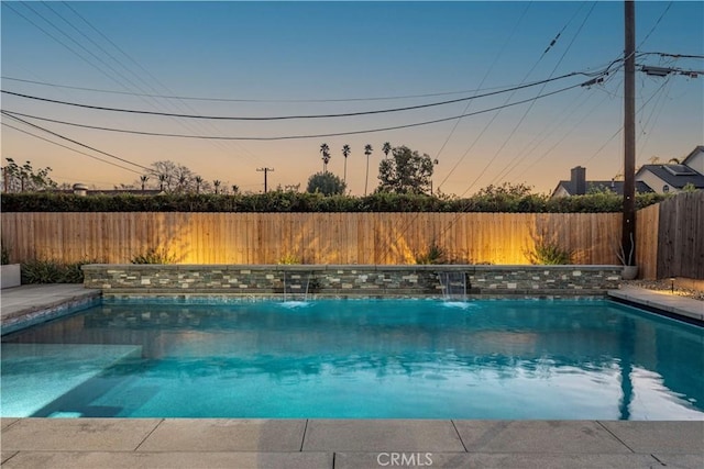 pool at dusk with pool water feature