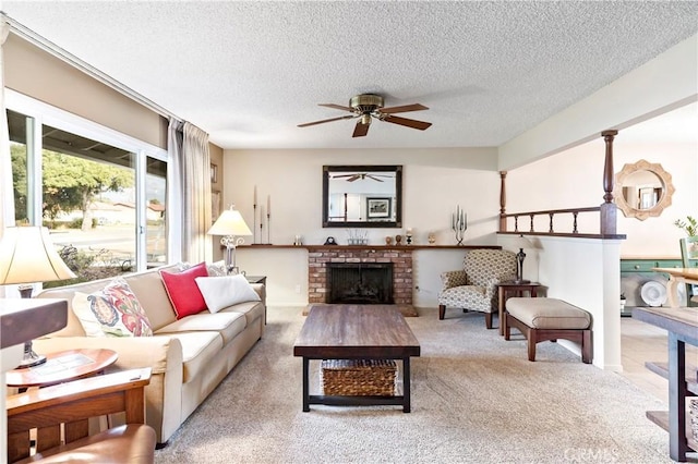 carpeted living room featuring ceiling fan, a fireplace, and a textured ceiling