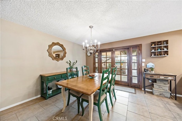 dining space with a notable chandelier, french doors, light tile patterned floors, and a textured ceiling