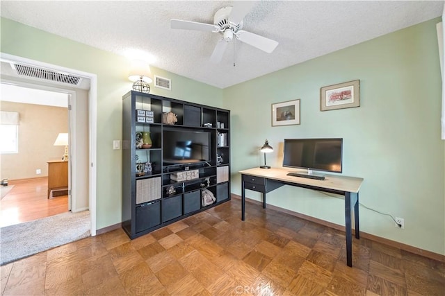 office space featuring ceiling fan, a textured ceiling, and parquet floors