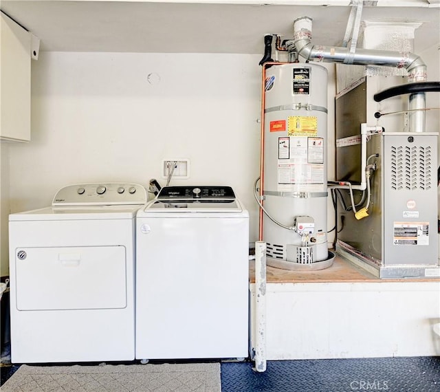 clothes washing area with washing machine and clothes dryer and strapped water heater