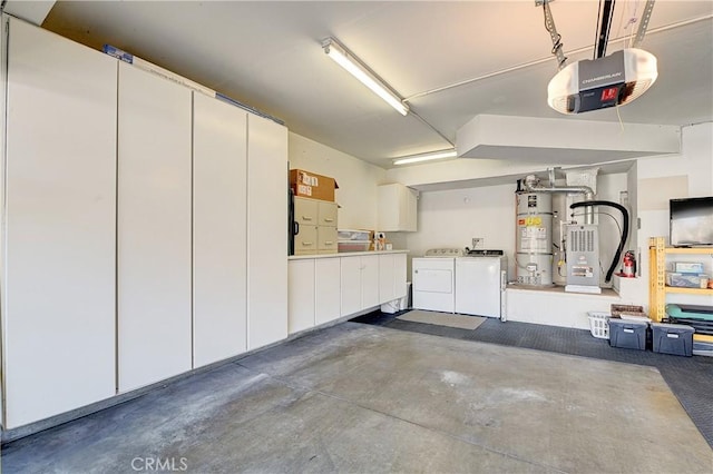 garage featuring water heater, a garage door opener, and washer and clothes dryer