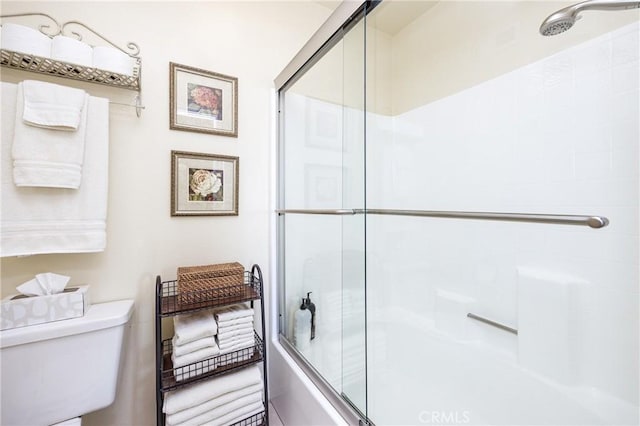 bathroom with shower / bath combination with glass door and toilet