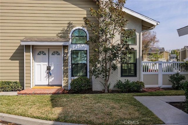 view of exterior entry featuring a yard