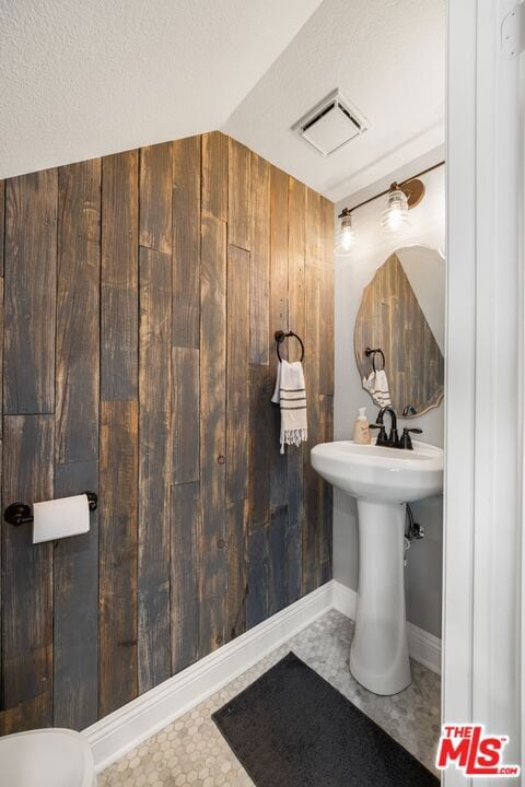 bathroom featuring a textured ceiling and lofted ceiling