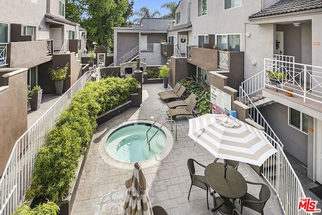 view of swimming pool with a patio area and a community hot tub