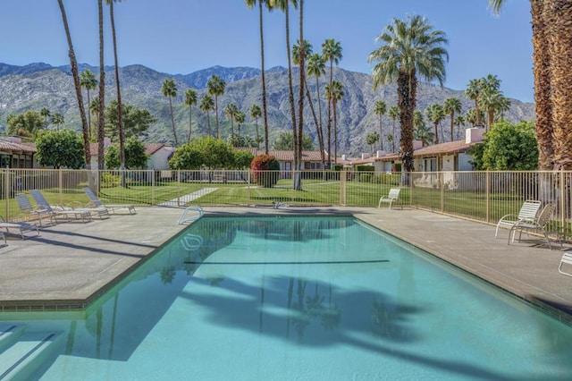 view of swimming pool with a mountain view, a patio area, and a yard