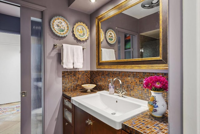 bathroom with tasteful backsplash, tile patterned floors, and vanity