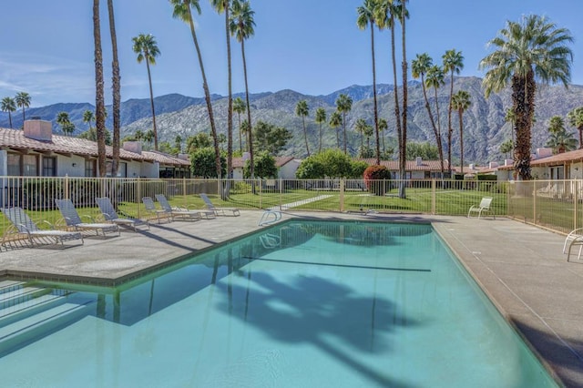 view of pool featuring a mountain view, a patio, and a lawn