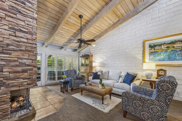 interior space with beamed ceiling, a fireplace, brick wall, high vaulted ceiling, and ceiling fan