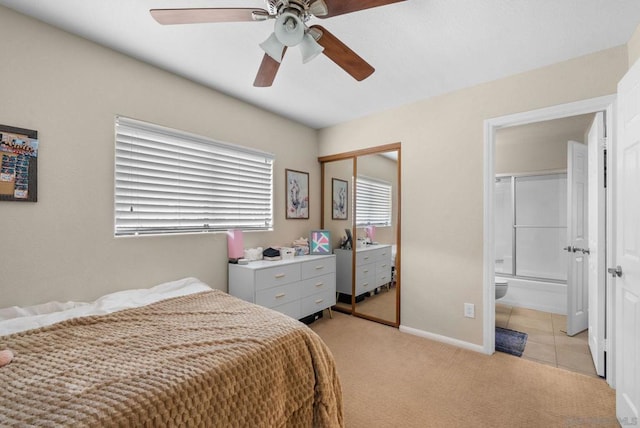 bedroom with light colored carpet, a closet, ceiling fan, and connected bathroom