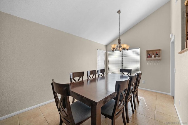 dining space featuring an inviting chandelier, light tile patterned floors, and lofted ceiling