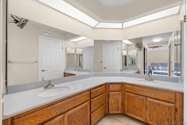 bathroom with vanity, a skylight, and tile patterned floors