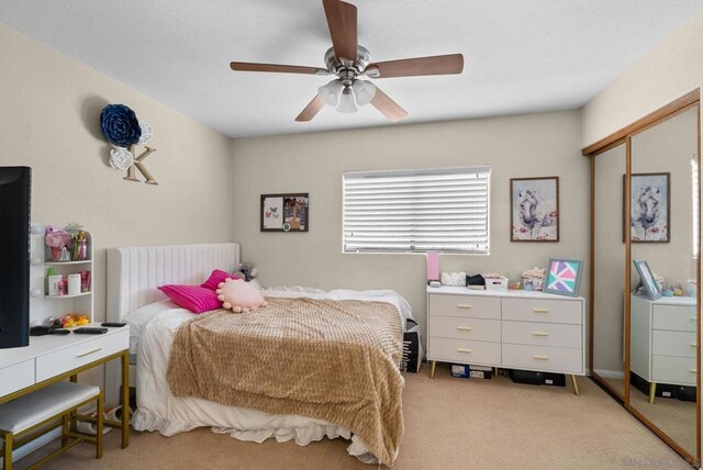 bedroom with light carpet, a closet, ceiling fan, and radiator