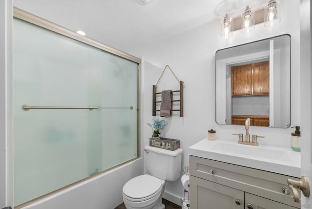 full bathroom with bath / shower combo with glass door, toilet, and vanity