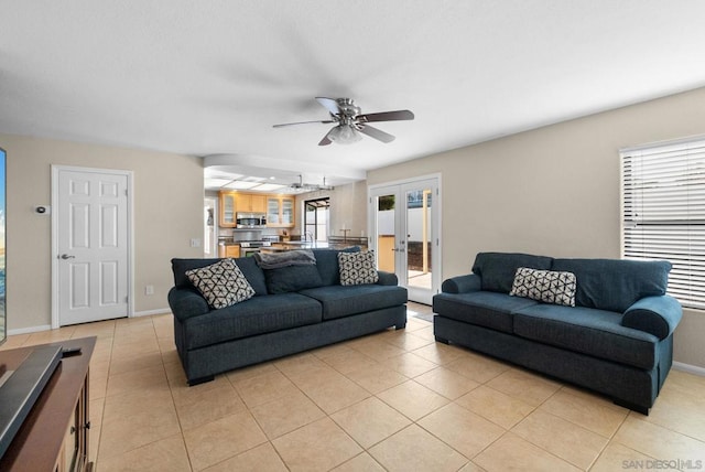 tiled living room featuring ceiling fan, french doors, and a healthy amount of sunlight