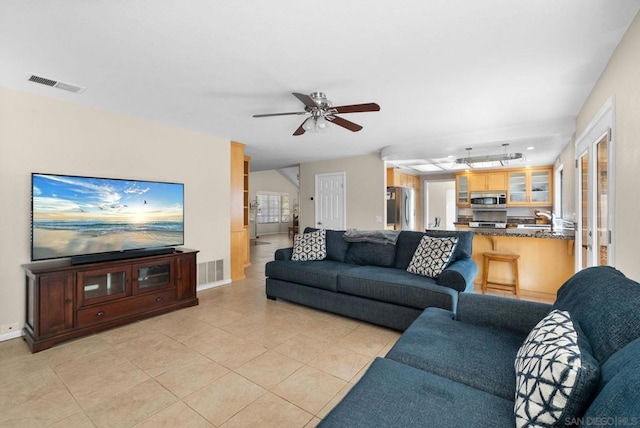 tiled living room with ceiling fan