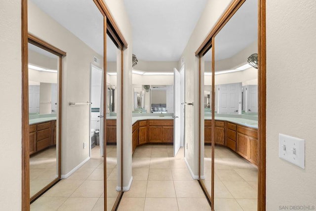 hallway with sink and light tile patterned floors