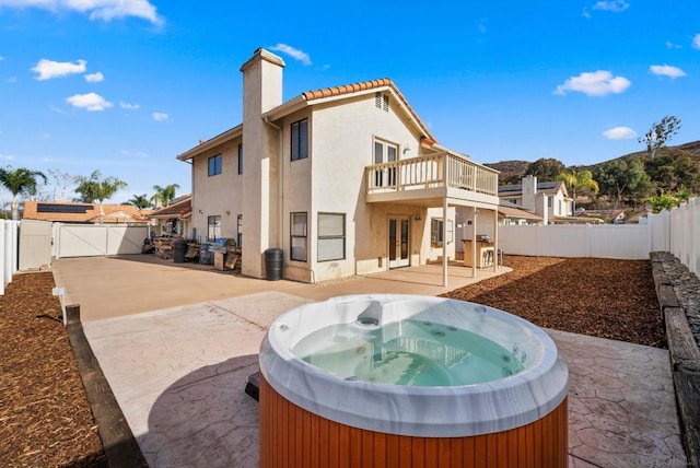 rear view of house with a patio and a hot tub