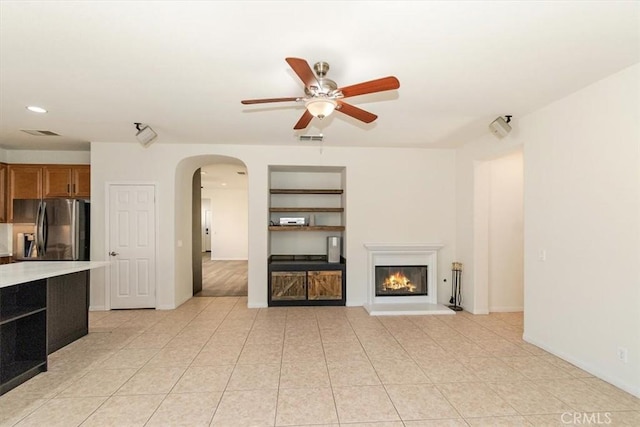 unfurnished living room with ceiling fan