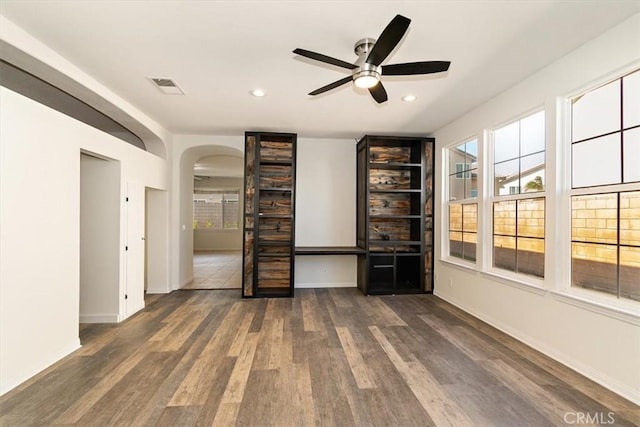 unfurnished living room with dark hardwood / wood-style floors and ceiling fan