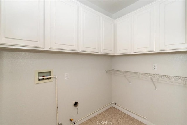 laundry area with gas dryer hookup, cabinets, light tile patterned floors, electric dryer hookup, and washer hookup