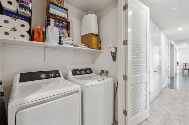 laundry area featuring light carpet and washer and clothes dryer