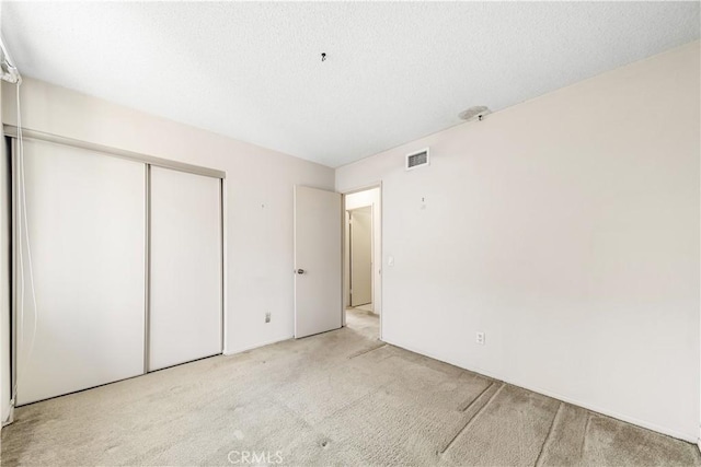 unfurnished bedroom featuring a closet and light carpet