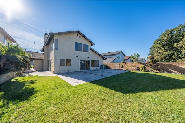 back of house with central air condition unit, a patio area, and a yard